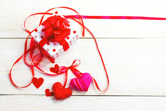 gift with red ribbons and soft hearts of different tissues, background for Valentine's Day greetings