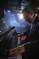 Side view of a male pianist performing in jazz club