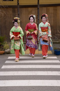 Foto Stock Maiko (apprentice geisha) walking in the streets of the Gion  district wearing traditional Japanese kimono and okobo (tall wooden shoes),  Kyoto, Kansai region, island of Honshu, Japan | Adobe Stock