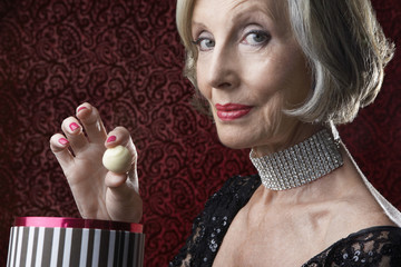 Closeup portrait of a wealthy senior woman with box of candy