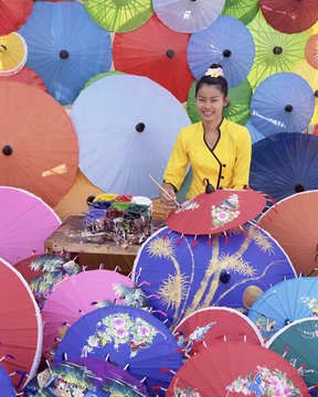 Woman painting umbrellas, umbrella making factory, Bo Sang umbrella village, Bo Sang, Chiang Mai, northern Thailand