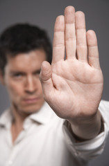 Closeup of a male executive holding out hand against gray background