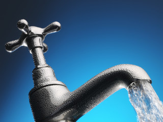 Water pouring from tap close-up