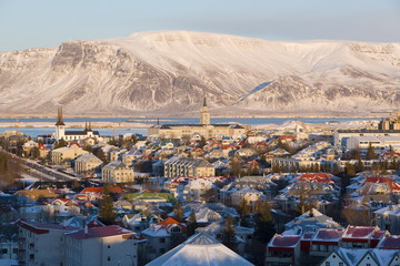 Elevated view over the churches and city, with a backdrop of snow capped mountains, Reykjavik, Iceland