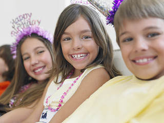 Closeup portrait of smiling children sitting in row at birthday party