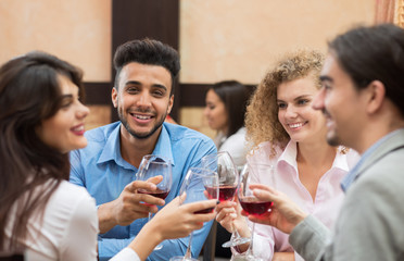 Young Business People Group Sitting At Cafe Table Toasting, Hold Wine Glasses, Friends Cheers Happy Communication Event Celebration