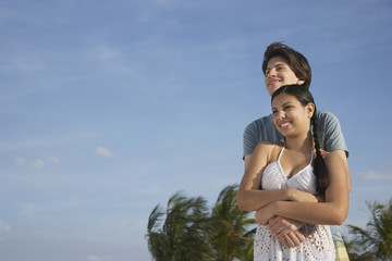 Fototapeta na wymiar Romantic teenage couple embracing on tropical beach
