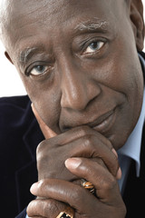 Closeup portrait of an African American senior businessman against white background