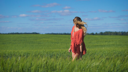 Charming blonde woman at a green field