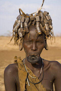 Portait of a Mursi girl with clay lip plate, and hairstyle that indicates she is going through puberty,The Mursi Hills, Mago National Park, Lower Omo Valley, Ethiopia