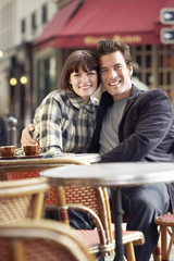 Portrait of a happy young couple sitting at an outdoor cafe