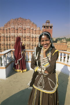 Women in saris in front of the facade of the Palace of the Winds (Hawa Mahal), Jaipur, Rajasthan state