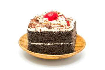 Chocolate cake garnished with cherry and white cream
