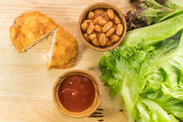 Top view of chicken cordon bleu, white bean, tomato sauce and ve