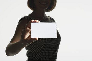 Midsection of silhouette woman with a blank card on white background