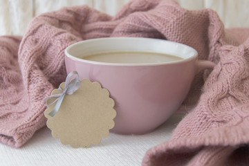 Cup of coffee, sweater and tag