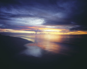 Sunset and Overcast Sky Over Beach