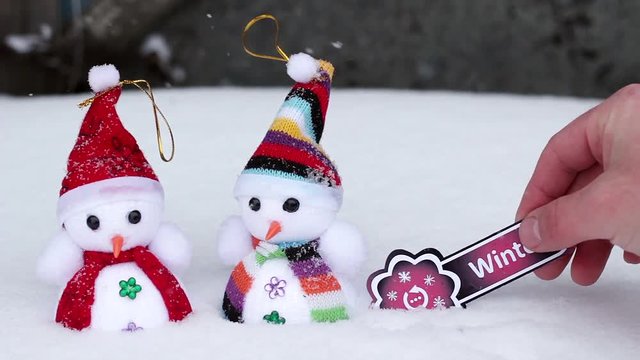 Two snowmen and winter sign