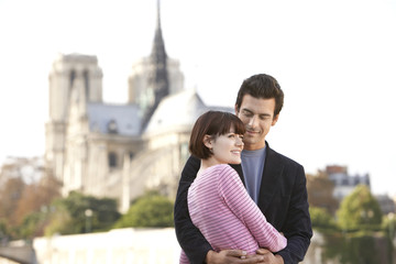 Loving couple standing in front of Notre Dame Cathedral