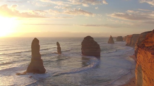 AERIAL: Flying along splendid rocky pillars and high limestone cliffs at sunset