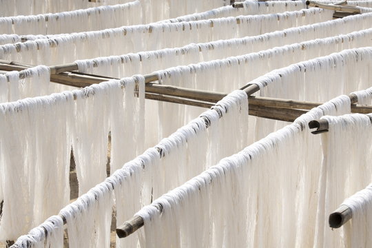 White silk drying in the sun on bamboo racks, Amarapura, near Mandalay