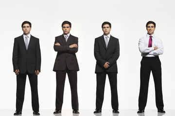 Full length portrait of businessmen standing side by side against white background