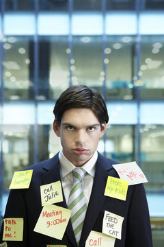 Portrait Of A Young Businessman Covered With Post It Notes