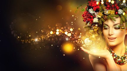Christmas magic. Beauty fashion model over holiday blurred background