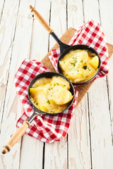 Melted raclette cheese on fresh potatoes