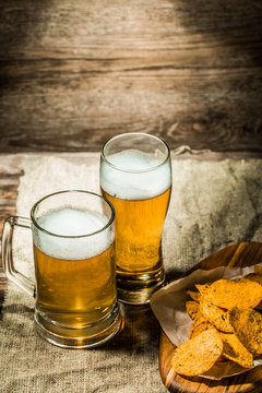 Beer in mug, glass on wooden background