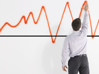 Rear view of a businessman looking at graph