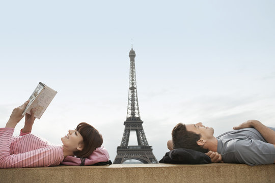 Side view of a couple lying with Eiffel Tower viewed in the background