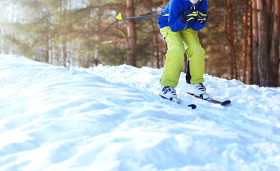 Fototapeta na wymiar Winter skier teenager in sportswear skiing over snow at sunny fo