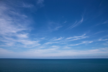 Fototapeta na wymiar Clouds, blue sky, calm sea. And skyline