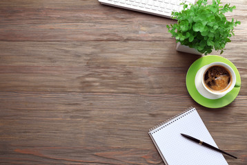 Cup of coffee with office tools on wooden background