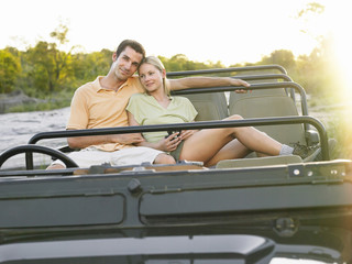 Portrait of a loving young couple sitting in jeep © MDBPIXS