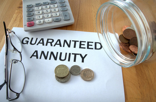 Guaranteed Annuity with coins from savings jar, calculator and glasses