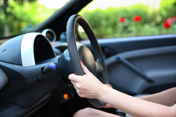 Female hands and steering wheel, closeup