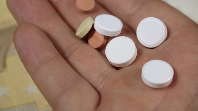 Different types of pills in man hand