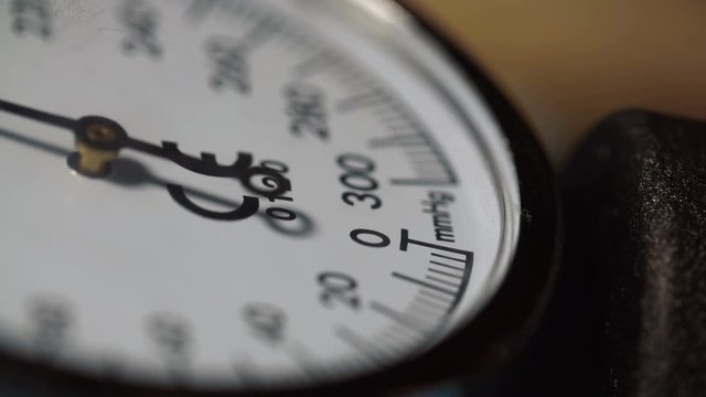 Extreme close-up nurse measures blood pressure with sphygmometer