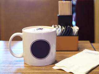  Close up of a cup of hot coffee latte on a wooden table.