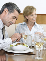 Businessman having food with female colleague at restaurant
