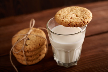 Cookies and milk. Chocolate chip cookies and a glass of milk. Vintage look. Tasty cookies and glass of milk on rustic wooden background. Food, junk-food, culinary, baking and eating concept