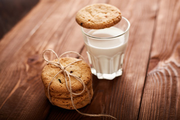 Cookies and milk. Chocolate chip cookies and a glass of milk. Vintage look. Tasty cookies and glass of milk on rustic wooden background. Food, junk-food, culinary, baking and eating concept