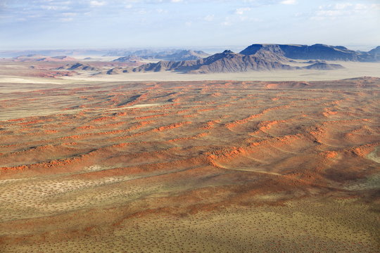 Aerial view from hot air balloon over magnificent desert landscape of sand dunes, mountains and Fairy Circles, Namib Rand game reserve Namib Naukluft Park, Namibia