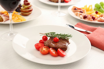 Steak and appetizers with wine on table