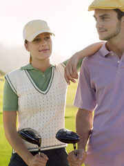 Young female golfer with male friend on golf course