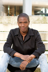 Handsome african american man sitting outside on stairs