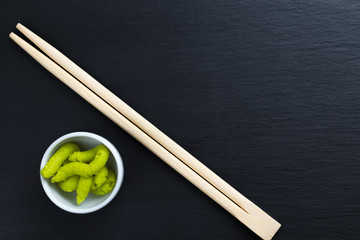 Japanese horseradish wasabi in small white bowl with chopsticks.