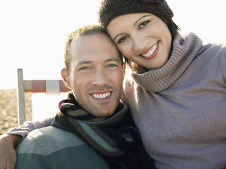 Closeup portrait of a cheerful couple sitting on deckchair at beach